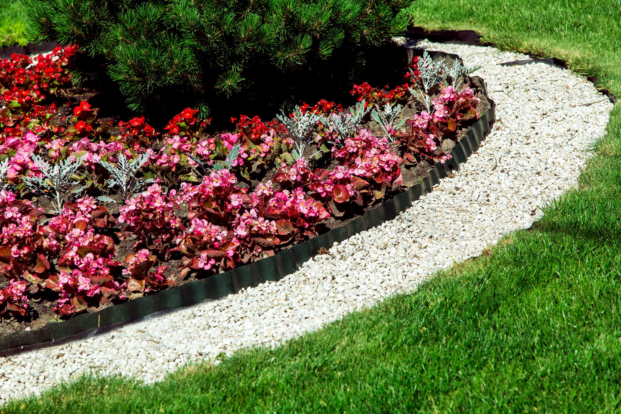 Grey garden pebbles used as edging for flowerbeds
